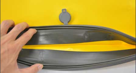 Natural rubber sealing strip with fold-over flap and central compression strap on an IPX8 pack